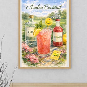 May include: A framed watercolor print of an "Azalea Cocktail" with a golf course backdrop. The image features a cocktail, gin, grenadine, and a golf-themed marker. The drink is garnished with mint and a lemon slice. The print is in a wooden frame.