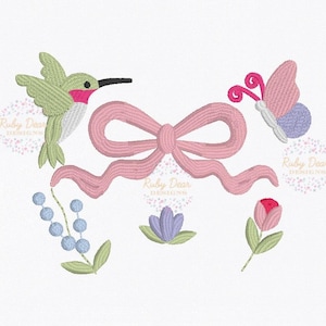 May include: An embroidered design featuring a hummingbird, a pink bow, a butterfly, a cluster of blue berries, a purple flower, and a pink rose. The design is on a white background. The text "Ruby Dear Designs" is in the background.