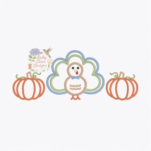 May include: An embroidered design featuring a turkey with a blue bow tie, flanked by two orange pumpkins. The turkey has a brown body and a blue and green outline. The pumpkins have green stalks. The design is set against a white background.
