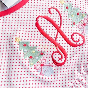 May include: A white fabric with red polka dots and embroidered Christmas trees and a red letter "J".
