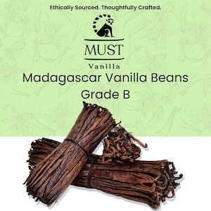 May include: A product label for MUST Madagascar Vanilla Beans Grade B featuring a lemur logo and the text Ethically Sourced. Thoughtfully Crafted. Below the label are two bundles of dark brown, dried vanilla beans tied with black elastic bands.