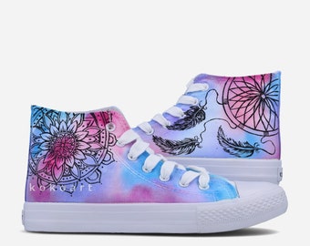 Könnte beinhalten: Weiße High-Top-Canvas-Schuhe mit einem Tie-Dye-Effekt in Pink, Blau und Lila. Die Schuhe sind mit schwarzen Tintenzeichnungen von Traumfängern und Federn verziert. Die Worte "kokocart" sind an der Seite der Schuhe geschrieben.