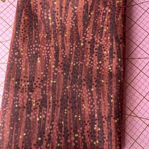 May include: Red fabric with a vertical stripe pattern and gold flecks.
