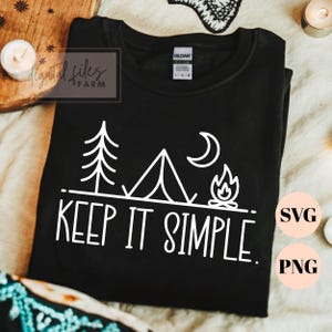 May include: Black crew neck sweatshirt with a white graphic of a tent, trees, moon, and campfire. The text "KEEP IT SIMPLE." is below the graphic. The sweatshirt has a Gildan tag.