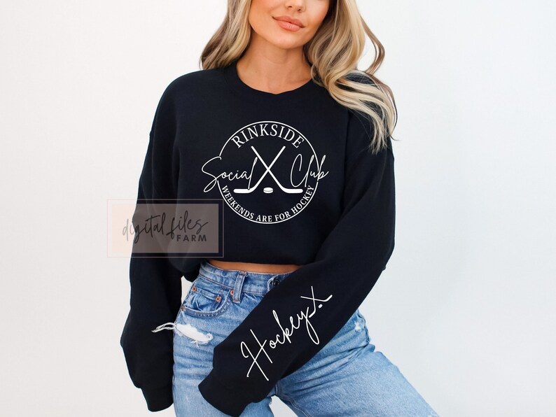 May include: Black cropped sweatshirt with a white circle graphic that says "rinkside social club" with hockey sticks and the text "weekends are for hockey". The sweatshirt has a white "hockey" written on the sleeve.