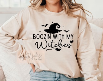 May include: A beige sweatshirt with a black graphic design that says "Boozin with my Witches" with a witch's hat, bats, and a heart.