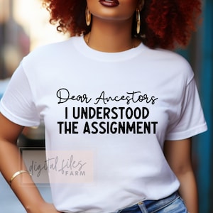 May include: A white t-shirt with black text that reads "Dear Ancestors I Understood The Assignment".