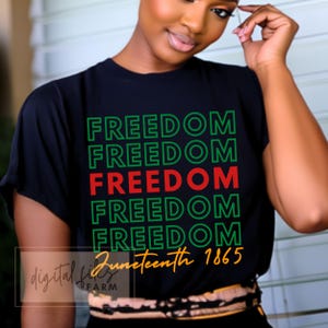 May include: Black t-shirt with the words "Freedom" repeated five times in green and red lettering. The text "Juneteenth 1865" is printed in orange below the word "Freedom".
