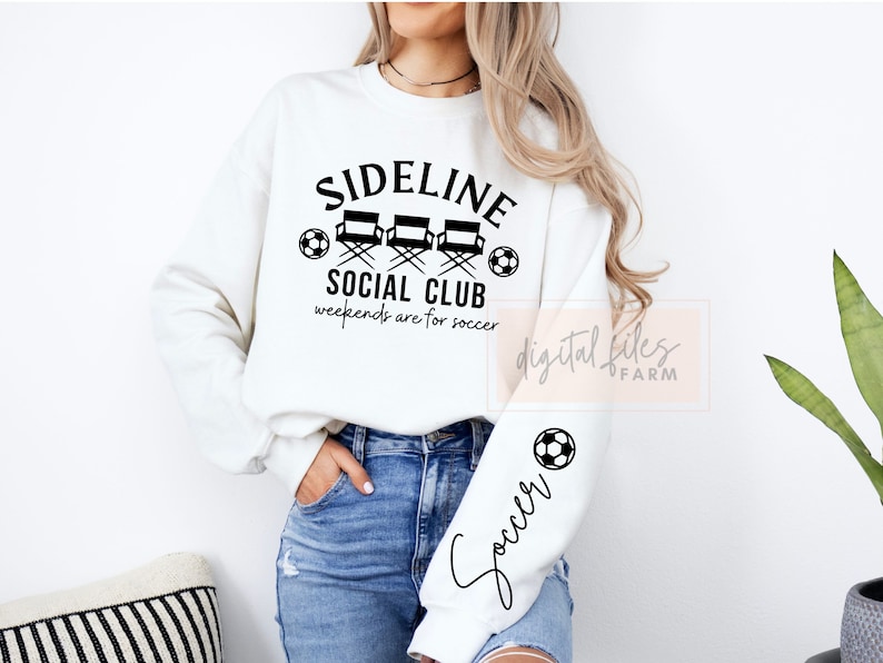 May include: White sweatshirt with black text that reads "Sideline Social Club" with three director's chairs and a soccer ball. The text below reads "weekends are for soccer". The left sleeve has a soccer ball and the word "Soccer" written in cursive.