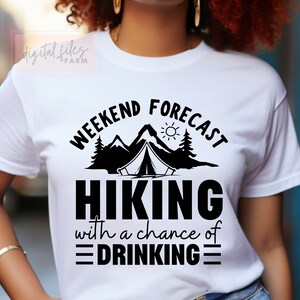 May include: White t-shirt with black text that reads "Weekend Forecast Hiking with a chance of Drinking" and a graphic of a tent, mountains, and a sun.