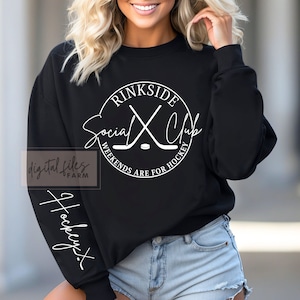 May include: Black sweatshirt with a white circle graphic that says "Rinkside Social Club Weekends Are For Hockey" with a hockey stick and puck design. The left sleeve has the word "Hockey" written vertically in white.