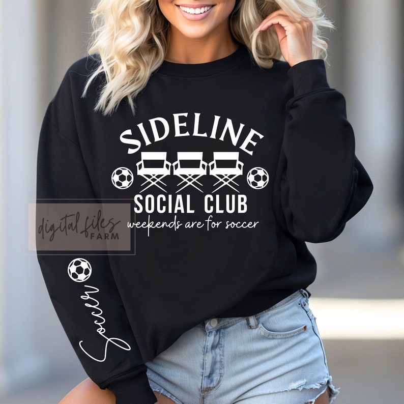 May include: Black sweatshirt with white text that reads "Sideline Social Club" and "Weekends are for soccer". The sweatshirt also features three white director's chairs and soccer balls.