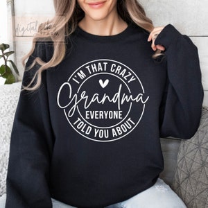 May include: Black sweatshirt with a white circle graphic that says "I'm that crazy Grandma everyone told you about" with a small heart in the center.