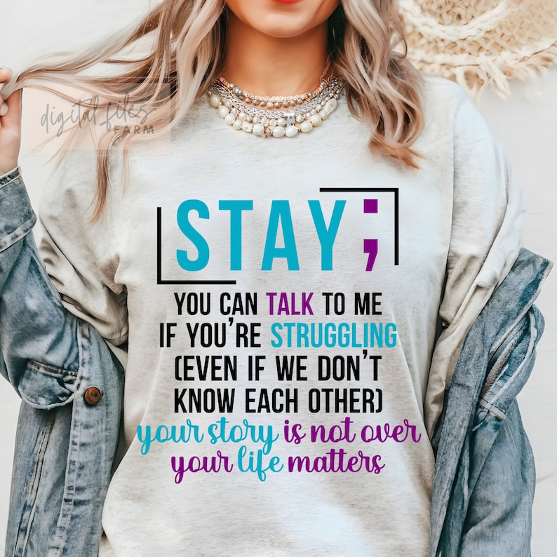 K&ouml;nnte beinhalten: Ein wei&szlig;es T-Shirt mit einer blaugr&uuml;nen und violetten Grafik, auf der "STAY; YOU CAN TALK TO ME IF YOU'RE STRUGGLING (EVEN IF WE DON'T KNOW EACH OTHER) your story is not over your life matters" steht.