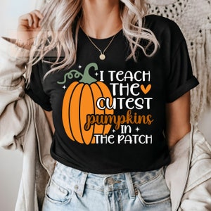 May include: Black t-shirt with a pumpkin graphic and the text "I teach the cutest pumpkins in the patch".