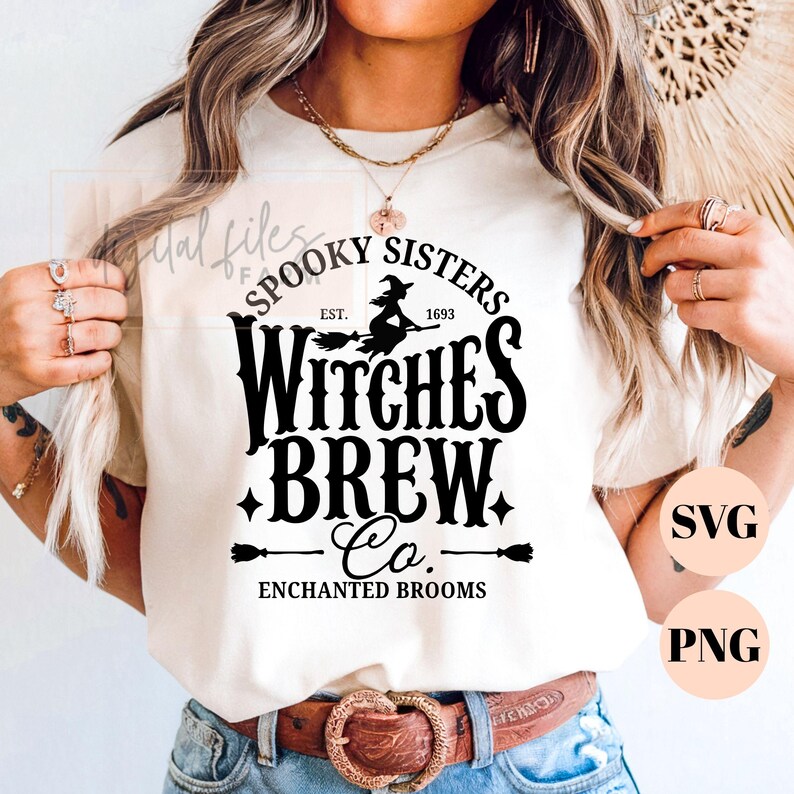 Pu&ograve; includere: Una t-shirt color crema con un design grafico nero che riporta il testo "SPOOKY SISTERS WITCHES BREW Co. ENCHANTED BROOMS EST. 1693" e l'illustrazione di una strega su una scopa, arricchita da piccole icone a forma di stella e scopa.
