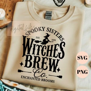 Pu&ograve; includere: Una felpa girocollo color beige con una stampa grafica nera che recita Spooky Sisters Est. 1693 Witches Brew Co. Enchanted Brooms. Il design include la sagoma di una strega su una scopa, piccole stelle e due icone di scope.