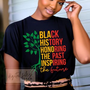 May include: Black t-shirt featuring the text "BLACK HISTORY HONORING THE PAST INSPIRING the future" in yellow, red, and green. A tree graphic is on the left. The shirt has a crew neck.
