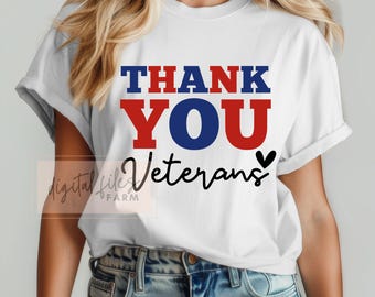 May include: White t-shirt with the text "THANK YOU VETERANS" in red, blue, and black lettering with a small black heart.