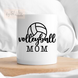 May include: White ceramic mug with a black volleyball graphic and the text "volleyball MOM".