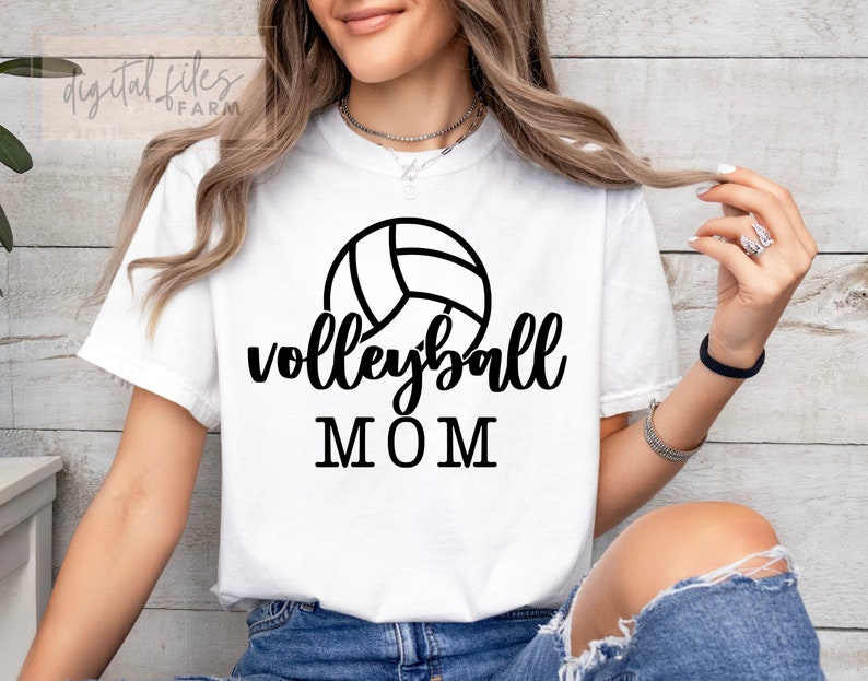 May include: White t-shirt with a black volleyball graphic and the text "volleyball MOM".