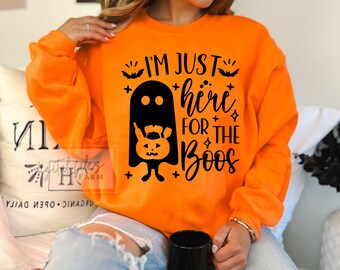 May include: Orange sweatshirt with a black ghost holding a pumpkin and the text "I'm just here for the boos".