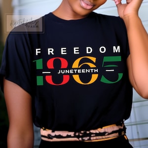 May include: A black t-shirt with the text "FREEDOM 1865 JUNETEENTH" in green, red and yellow lettering.