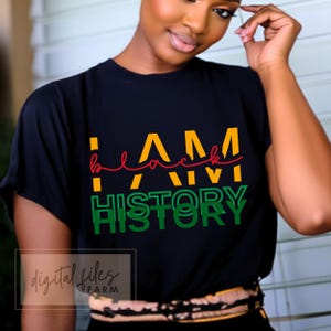 May include: A black t-shirt with the text "I AM black HISTORY" in yellow, red, and green lettering.