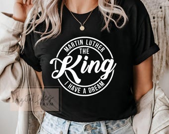 May include: Black t-shirt with a white circle graphic that says "Martin Luther King The King I Have A Dream".