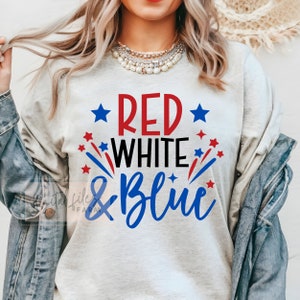 May include: A gray t-shirt with the text "Red White & Blue" in red, white, and blue lettering. The text is surrounded by red and blue stars.