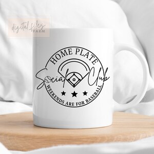 May include: White ceramic mug with a black and white graphic design. The design features a baseball field, three stars, and the text "Home Plate Social Club Weekends Are For Baseball".