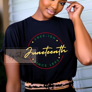 以下が含まれることがあります： 「Juneteenth Free-ish Since 1865」と書いてある金色の円形のグラフィックが描かれた黒いTシャツです。