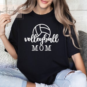 May include: Black t-shirt with a white volleyball graphic and the text "volleyball MOM" printed on the front.