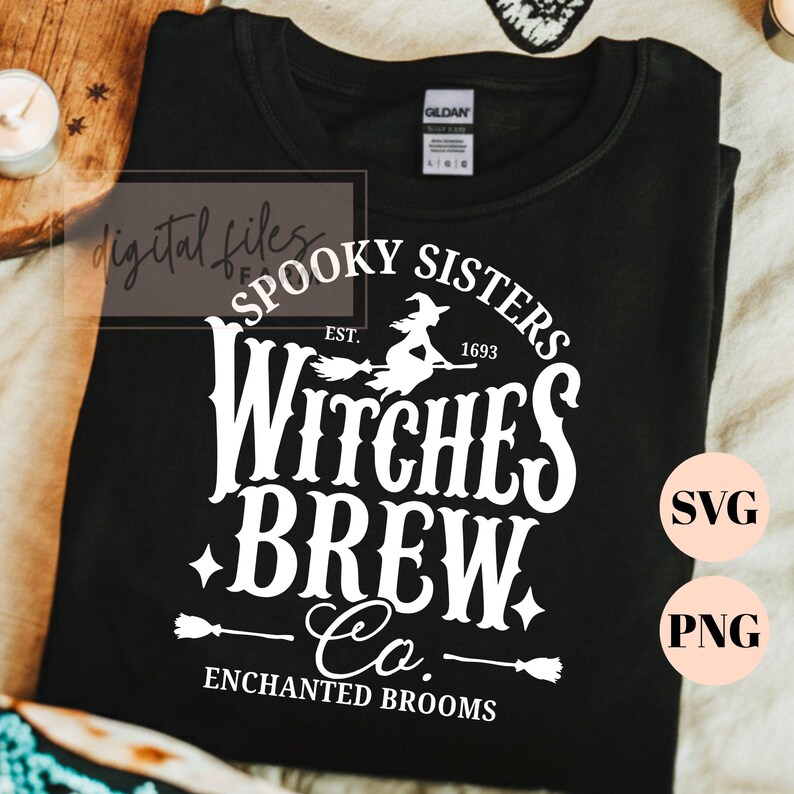 Pu&ograve; includere: Una t-shirt nera con una stampa grafica bianca che recita Spooky Sisters Witches Brew Co. Est. 1693 Enchanted Brooms. Il design include la sagoma di una strega su una scopa, stelle e icone di scope. La maglietta presenta un'etichetta Gildan.