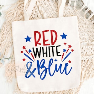May include: A white canvas tote bag with the text "RED WHITE & BLUE" in red, white, and blue lettering. The text is surrounded by red and blue stars.