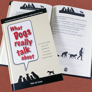 May include: A humorous book titled "What Dogs Really Talk About" by Nick da Costa. The cover features a speech bubble with the title and a silhouette of a dog walking with a human in the background.