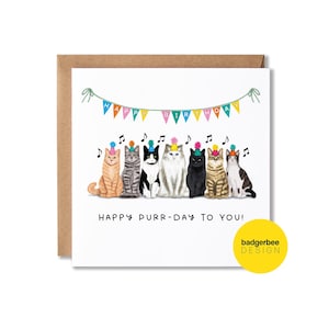 K&ouml;nnte beinhalten: Eine wei&szlig;e Karte mit einem bunten Banner, auf dem "Happy Birthday" steht, und einer Reihe von sieben Katzen, die Partyh&uuml;te tragen. Der Text unter den Katzen lautet "Happy Purr-Day To You!" und in der rechten unteren Ecke befindet sich ein gelber Kreis mit dem Text "badgerbee DESIGN".