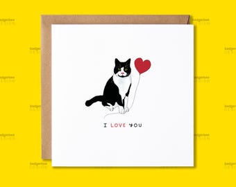 Puede incluir: Una tarjeta de felicitación con un gato blanco y negro sosteniendo un globo rojo en forma de corazón. La tarjeta dice "Te amo".