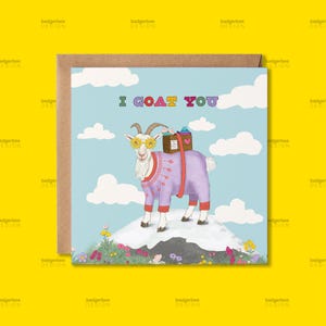 May include: A square greeting card with a cartoon goat wearing a purple sweater and sunglasses, standing on a snowy hill. The text "I GOAT YOU" is above the goat. The goat has a box on its back with a heart. The background is a blue sky with clouds.