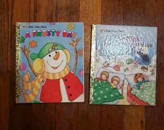 May include: Two Little Golden Books, one titled "A Frosty Day" featuring a snowman wearing a red vest, yellow scarf, and a green hat, and the other titled "The Night Before Christmas" featuring a scene of children sleeping in their beds.