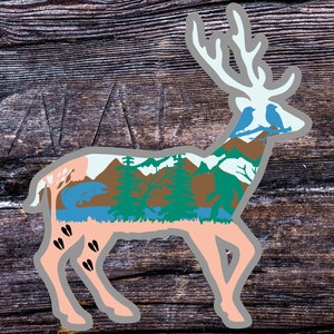 May include: A stylised deer silhouette with a landscape scene inside. The deer is light pink with a grey outline. The landscape includes mountains, trees, a lake, a fish, and birds. The deer has a white outline and antlers.