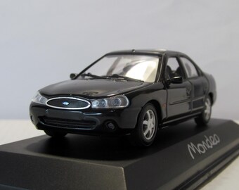May include: A black Ford Mondeo model car on a black display stand. The model car has silver wheels and clear headlights. The word "Mondeo" is written in white script on the stand.