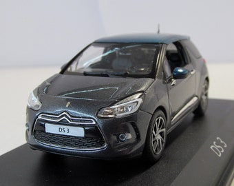 May include: A dark gray diecast model car of a Citroen DS3. The car has a black grille with the text "DS 3" in white. The car has a dark blue roof.
