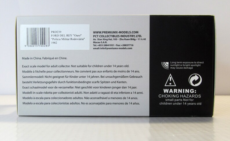 May include: A white box with black text and a barcode. The box is for a 1/43 scale model of a Ford Del Rey police car. The text on the box reads "PRD239 Ford Del Rey "Ouro" "Policia Militar Rodovi&aacute;ria" 1982". The box also includes a warning about choking hazards for children under 14 years old.