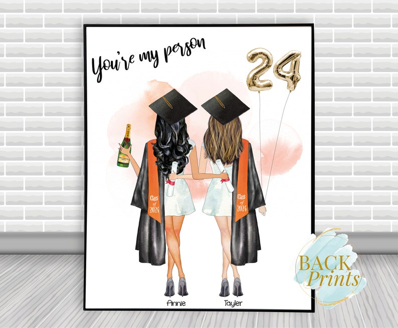 Pu&ograve; includere: Stampa di laurea con due donne in cappelli e toge, che tengono diplomi e una bottiglia di champagne. Il testo "You're my person" e "24" &egrave; visibile. I nomi delle donne "Annie" e "Taylor" sono in fondo alla stampa.