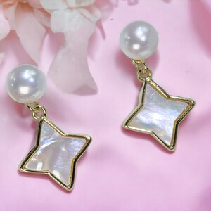 May include: A pair of gold earrings with a white pearl and a star-shaped pendant made of iridescent mother-of-pearl.