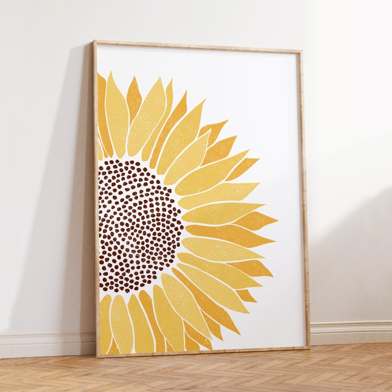 Puede incluir: Un gran girasol en forma de semic&iacute;rculo con p&eacute;talos amarillos y un centro marr&oacute;n. El girasol est&aacute; impreso sobre un fondo blanco y enmarcado en un marco de madera claro.