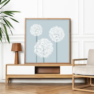 May include: A framed print of three white flower clusters on a light blue background. The flowers are stylized and resemble allium or globe thistle.