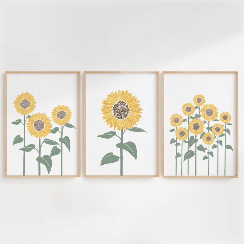 K&ouml;nnte beinhalten: Ein Set aus drei gerahmten Wandbildern mit Sonnenblumen-Illustrationen. Das linke Bild zeigt drei Sonnenblumen, das mittlere eine gro&szlig;e Sonnenblume und das rechte acht Sonnenblumen, alle mit gelben Bl&uuml;tenbl&auml;ttern und gr&uuml;nen St&auml;ngeln.