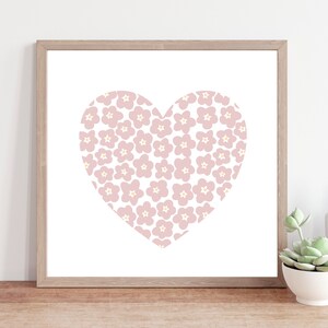 May include: A framed print of a pink heart with a white background. The heart is filled with a pattern of small pink flowers with white centers.